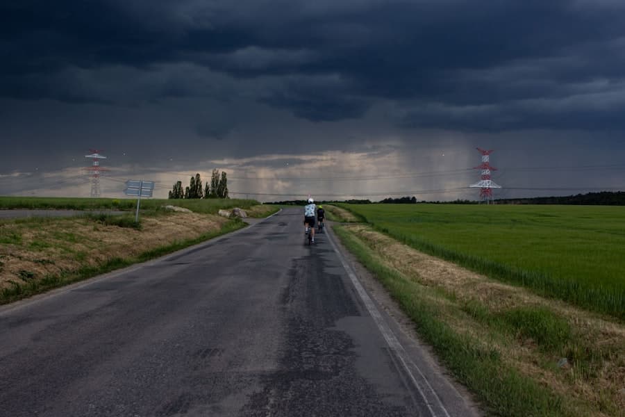 Cyclist on wet road under stormy sky with rain. Stock photograph, not taken at any listed clinic.