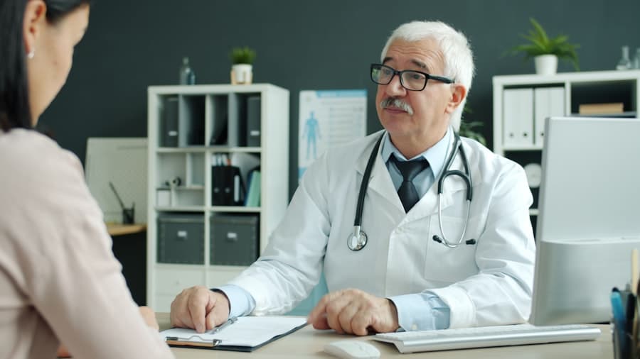 Doctor consults with patient in modern office. Stock photograph, not taken at any listed clinic.