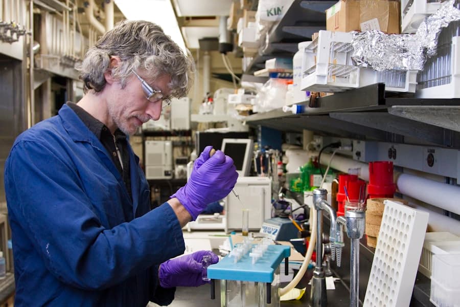 Woman dropping a specimen on a test tube. Stock photograph, not taken at any listed clinic.