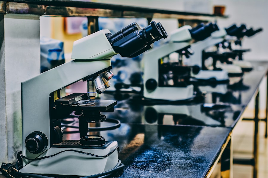 White microscope on top of black table. Stock photograph, not taken at any listed clinic.