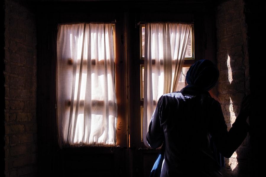 Person standing in front of window. Stock photograph, not taken at any listed clinic.