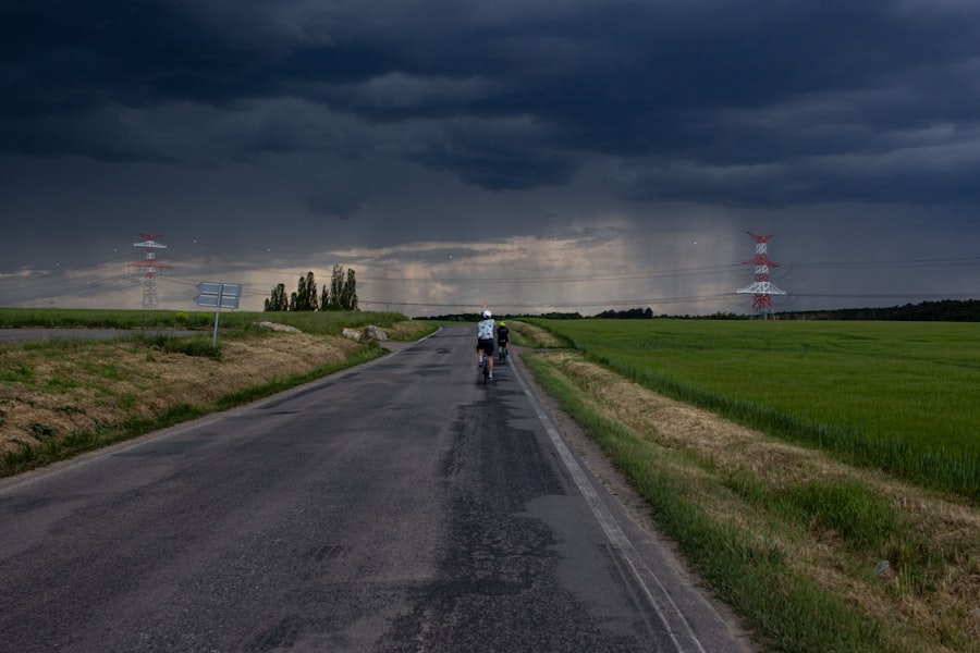 Cyclist on wet road under stormy sky with rain. Stock photograph, not taken at any listed clinic.