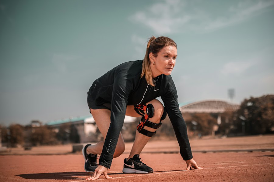 A woman crouches down to pick up a tennis ball. Stock photograph, not taken at any listed clinic.